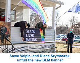 Steve Volpini and Diane Szymaszek unfurl the new BLM banner